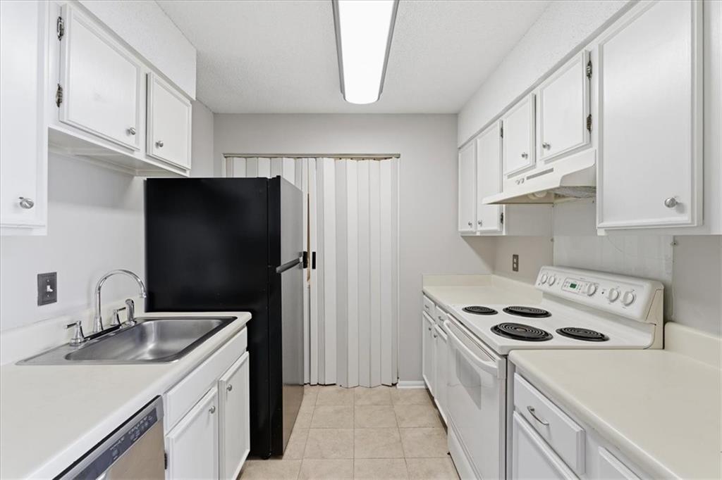 1166 Booth Road Southwest, Unit 906 Marietta, GA 30008 - Photo 22 of 27 a kitchen with stainless steel appliances granite countertop a sink stove and refrigerator