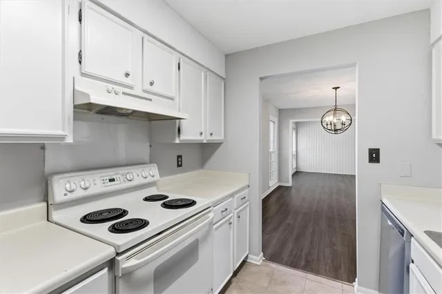 a kitchen with appliances cabinets and wooden floor