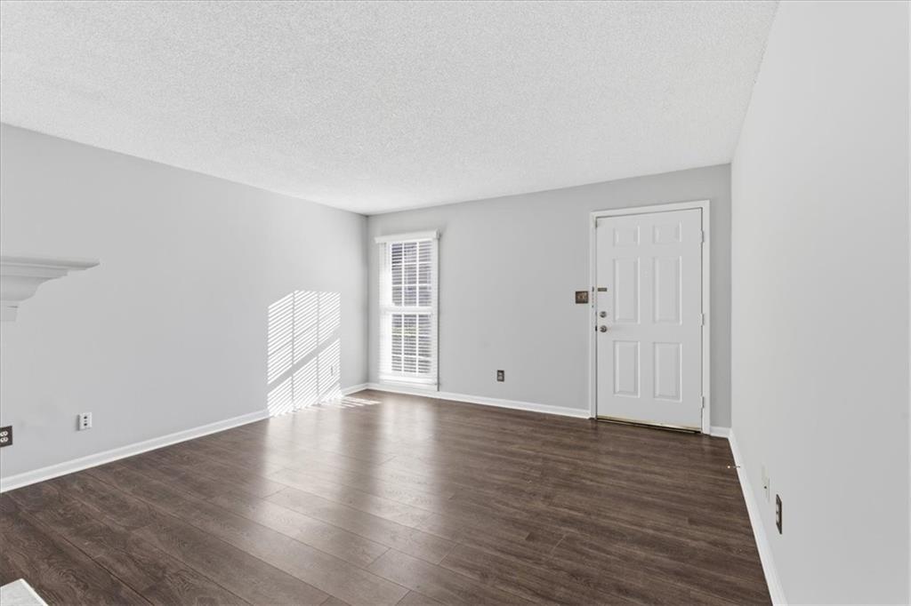 1166 Booth Road Southwest, Unit 906 Marietta, GA 30008 - Photo 4 of 27 a view of an empty room with wooden floor and a window