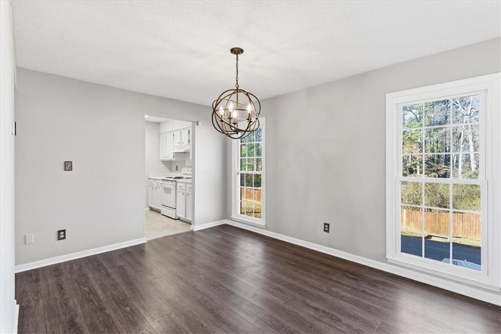 1166 Booth Road Southwest, Unit 906 Marietta, GA 30008 - Photo 6 of 27 a view of an empty room with wooden floor and a window