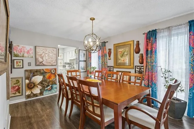 a dining room with furniture a chandelier and wooden floor