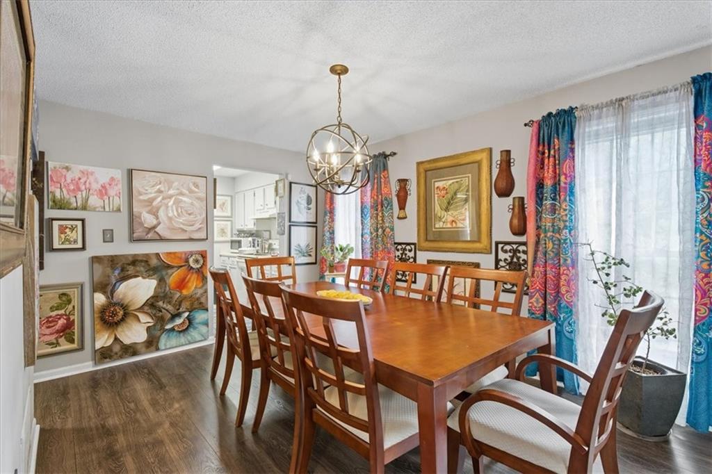 1166 Booth Road Southwest, Unit 906 Marietta, GA 30008 - Photo 7 of 27 a dining room with furniture a chandelier and wooden floor