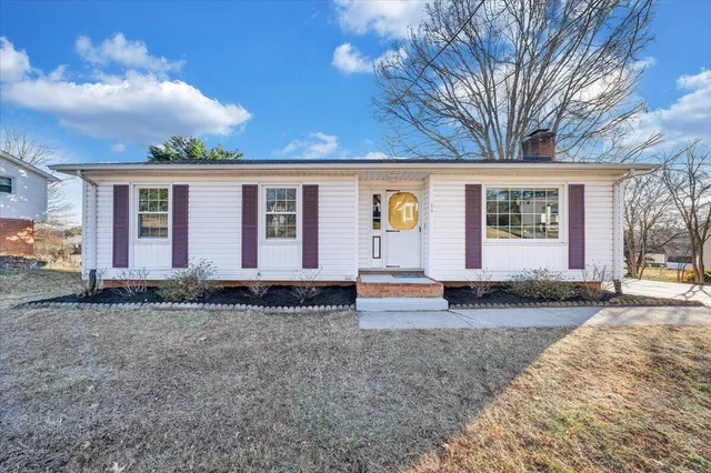a view of a house with a yard and wooden fence
