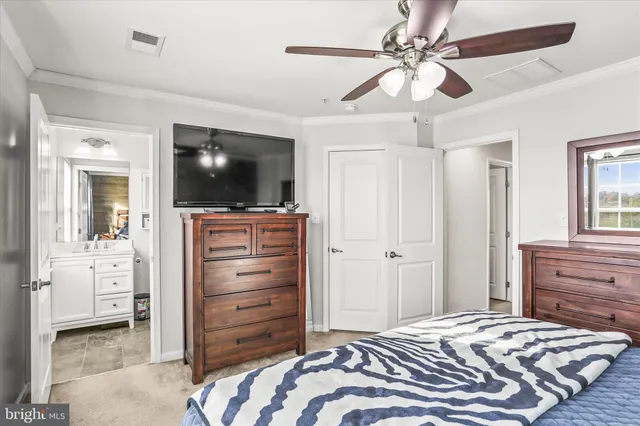 a bedroom with a bed and a flat tv screen on dresser