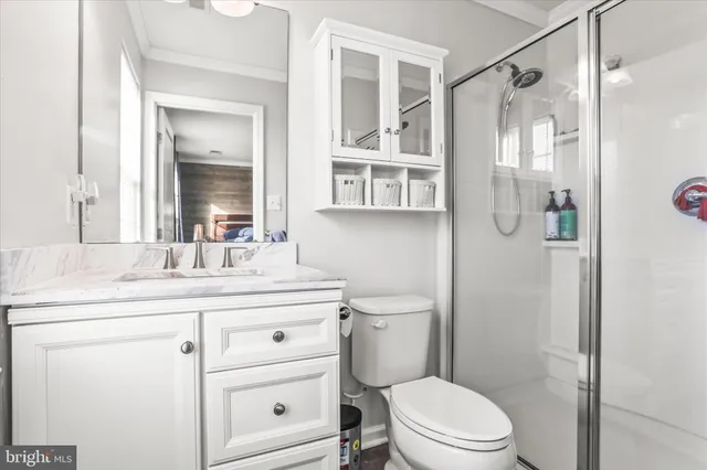 a bathroom with a granite countertop sink toilet a mirror a vanity and shower