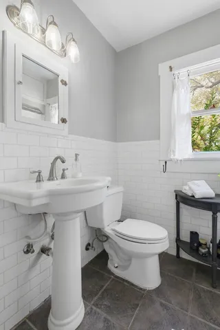 a bathroom with a sink toilet and mirror