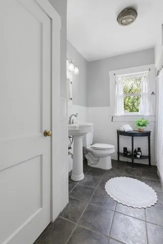 a bathroom with a toilet a sink and a window
