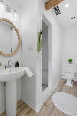 a bathroom with a sink a toilet and shower