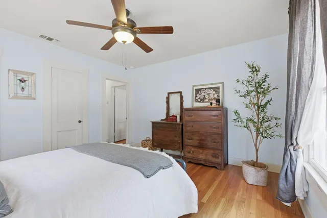 a bedroom with a bed chandelier and a window