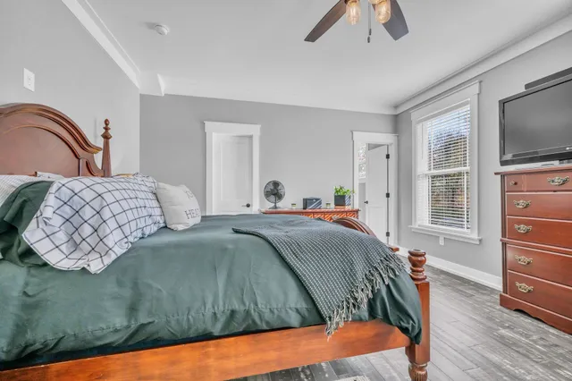 a spacious bathroom with a granite countertop sink toilet a mirror a vanity and shower