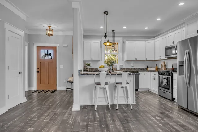 a kitchen with kitchen island white cabinets and stainless steel appliances