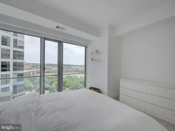 a bedroom with a bed and a large window