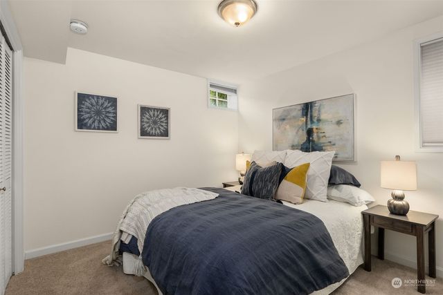 a bedroom with a bed and painting on the wall