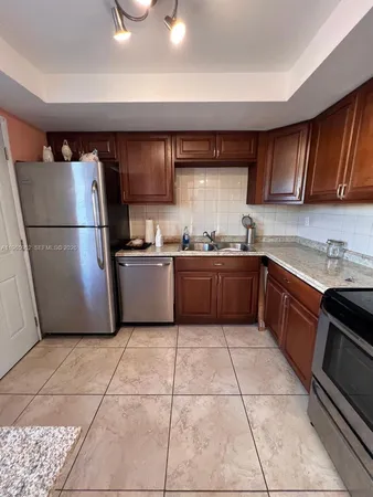 a kitchen with a sink a refrigerator and cabinets