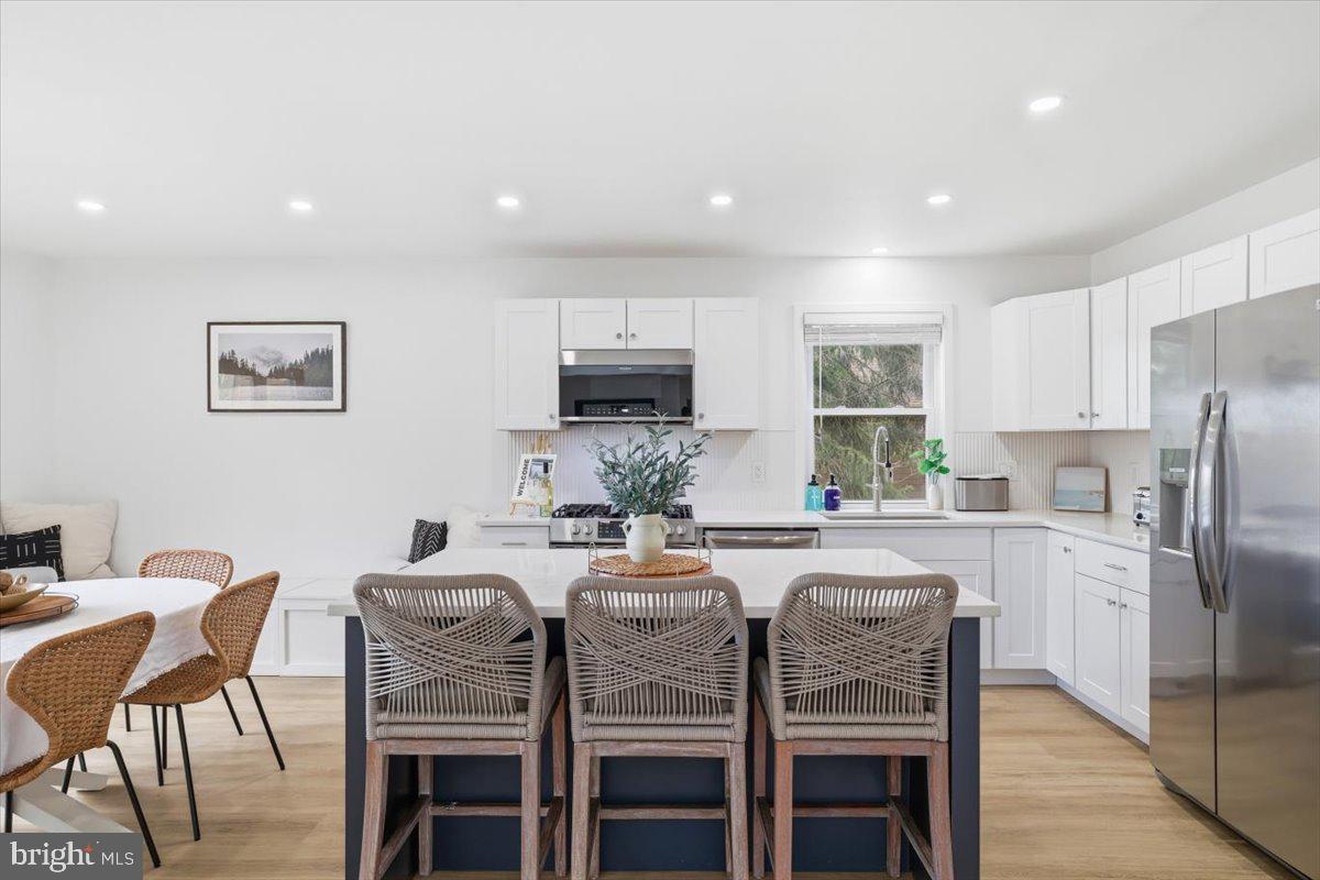 128 Lidio Road Blakeslee, PA 18610 - Photo 11 of 63 a kitchen with stainless steel appliances granite countertop a dining table chairs refrigerator and microwave