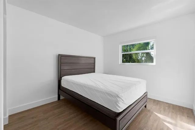 a bed sitting in a bedroom next to a window