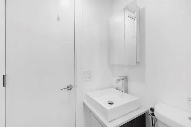 a white bed sitting in a bedroom next to a window