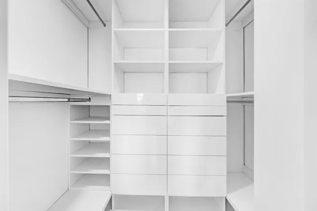 a view of empty room with kitchen and window