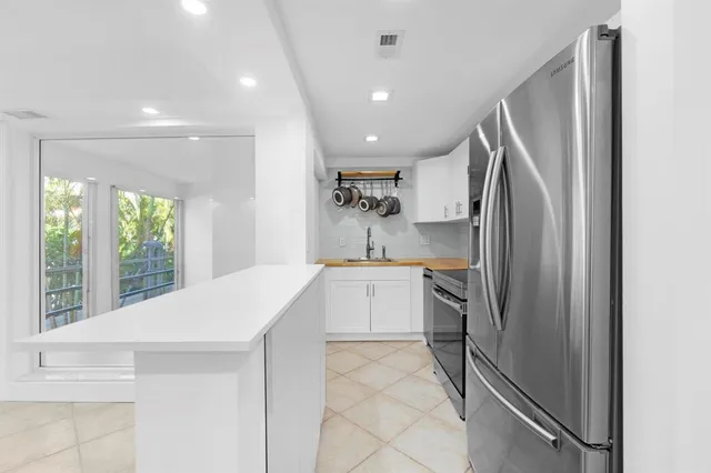 a kitchen with stainless steel appliances granite countertop white cabinets and a stove top oven