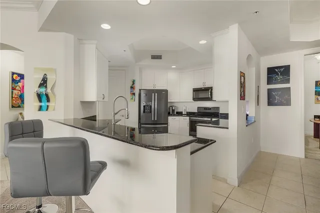 a kitchen with stainless steel appliances granite countertop a sink refrigerator and microwave