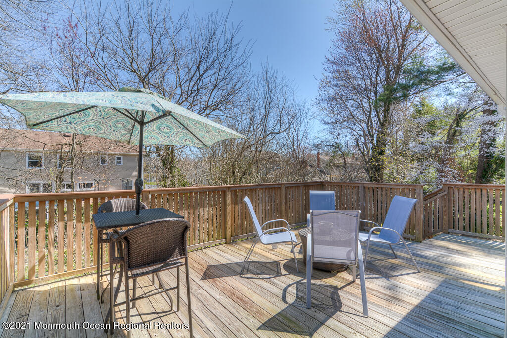 9 Neal Street Jackson, NJ 08527 - Photo 20 of 22 a patio table and chairs under an umbrella with wooden floor