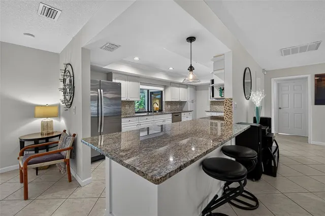 a spacious bedroom with a bed and a chandelier