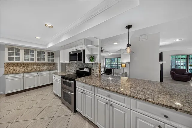 a spacious bedroom with a bed a chandelier and a dresser