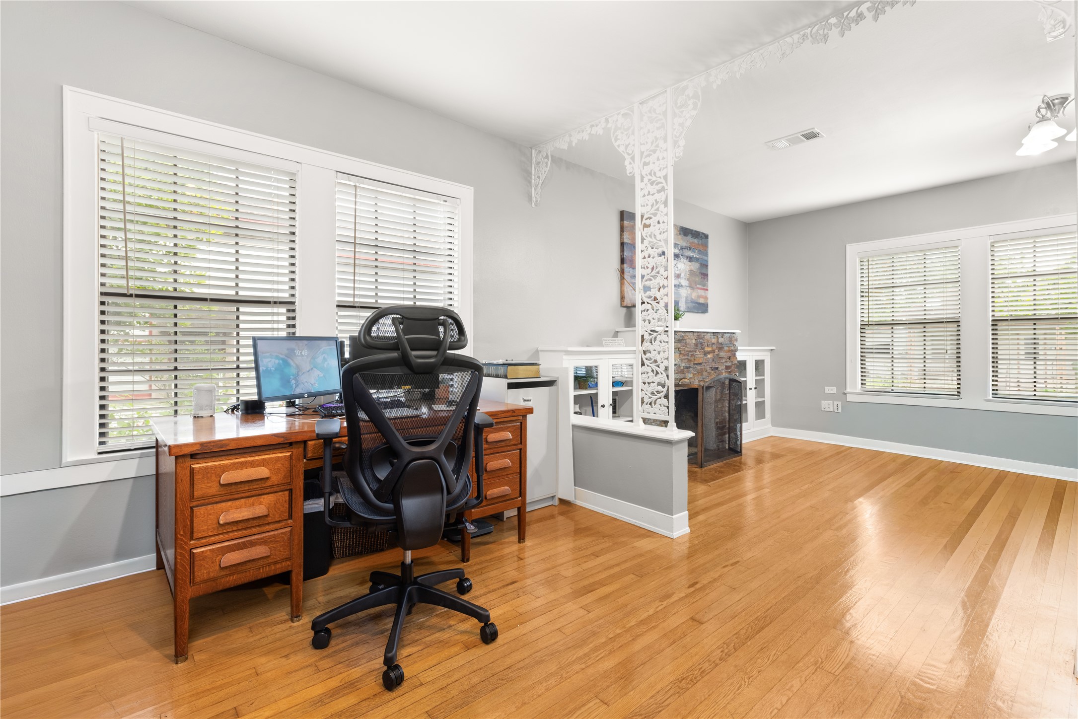 906 Higgins Street Humble, TX 77338 - Photo 14 of 26 This photo showcases the bright, open concept rooms with hardwood floors and large windows. It features a cozy workspace or a friendly reception area. Also useable as living and dining space.
