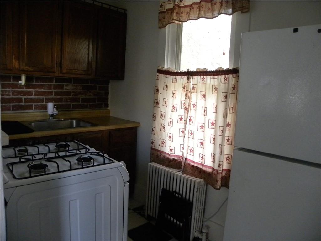 549 State Street Baden, PA 15005 - Photo 14 of 21 a kitchen with wooden cabinets and a stove top oven