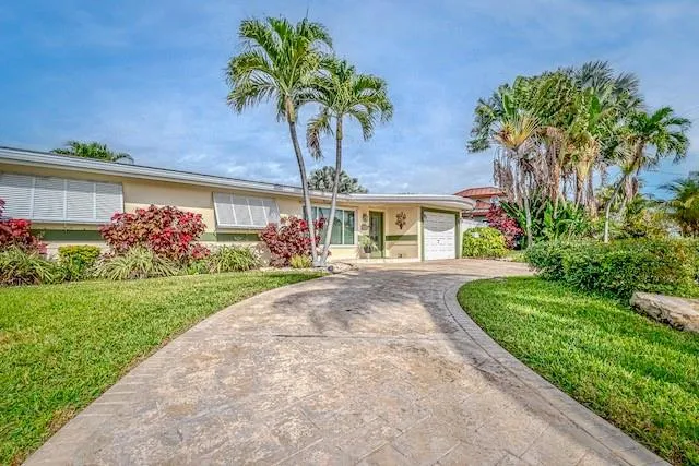 front view of a house with a yard and potted plants
