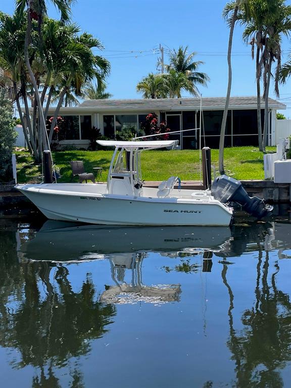 1131 Southeast 5th Avenue Pompano Beach, FL 33060 - Photo 39 of 39 a view of a swimming pool with lawn chairs potted plants and large tree