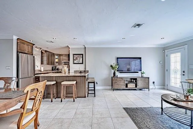 a living room with furniture a rug kitchen view and a window
