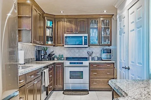 a kitchen with stainless steel appliances granite countertop a stove and cabinets