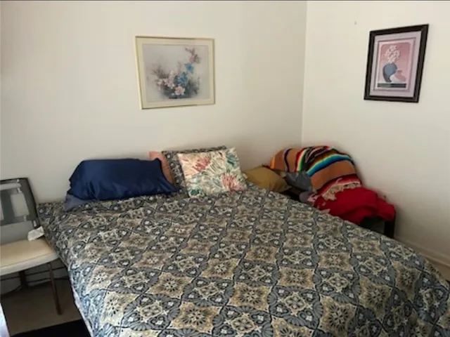 a bedroom with a bed and painting on the wall