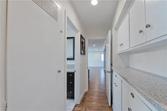a view of a hallway with white cabinets