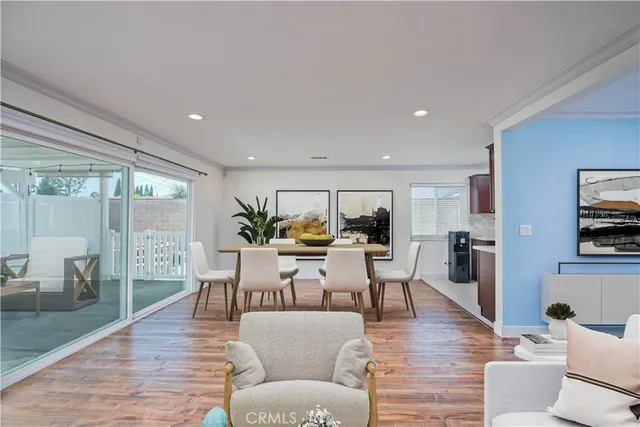 a living room with furniture a large window and wood floor