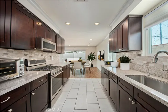 a kitchen with stainless steel appliances granite countertop wooden cabinets a sink dishwasher a stove top oven a sink and dishwasher