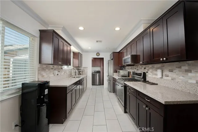 a kitchen with stainless steel appliances granite countertop wooden cabinets sink stove and granite counter top