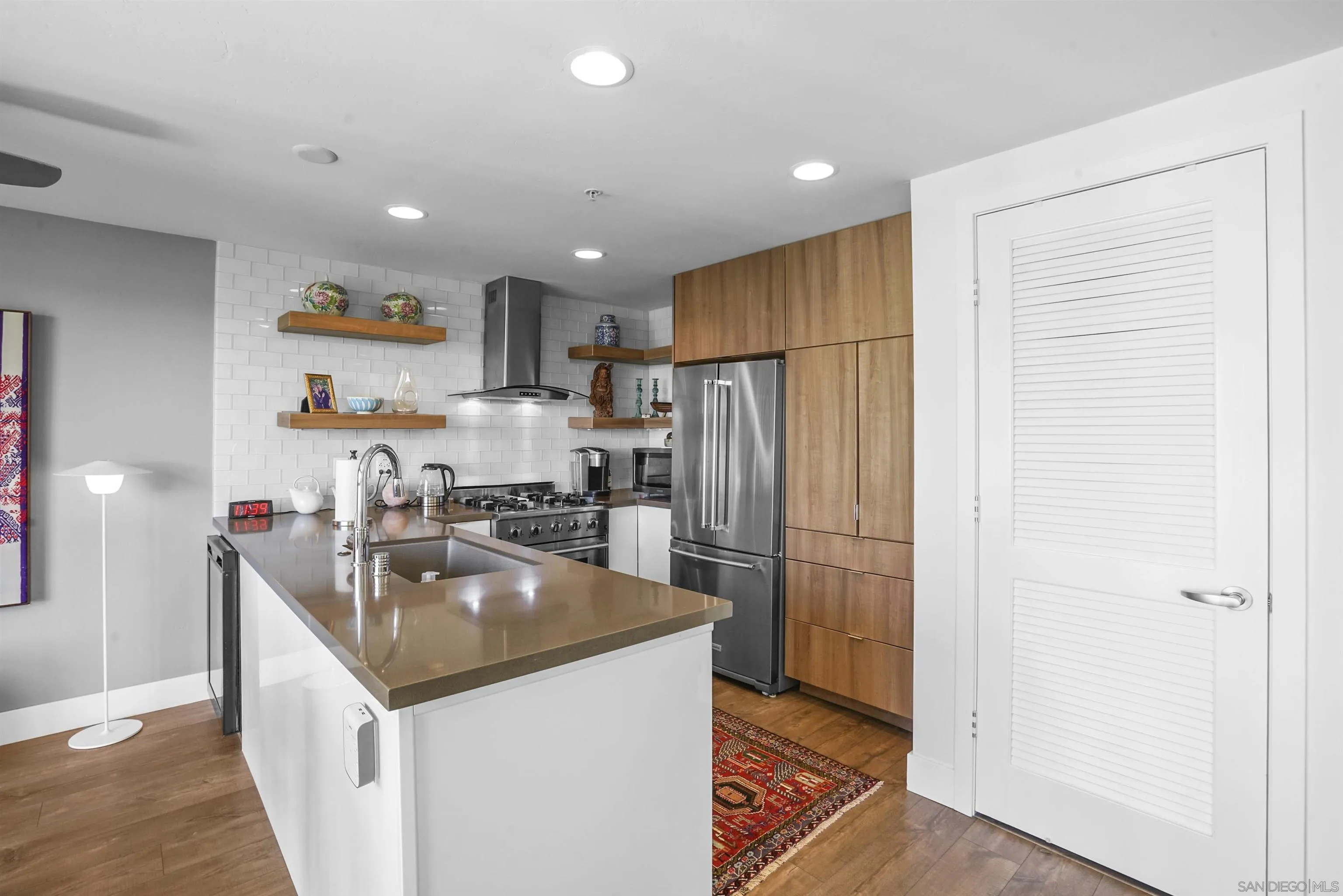 3812 Park Boulevard, Unit 503 San Diego, CA 92103 - Photo 9 of 27 a kitchen with kitchen island stainless steel appliances a refrigerator a sink a stove a microwave and cabinets