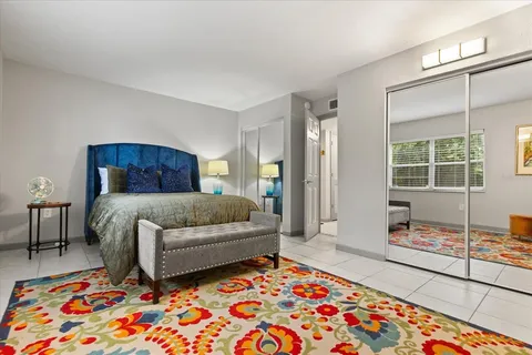 a bedroom with a bed and a lamp next to a window