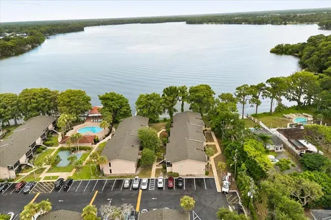 an aerial view of residential houses with outdoor space and lake view
