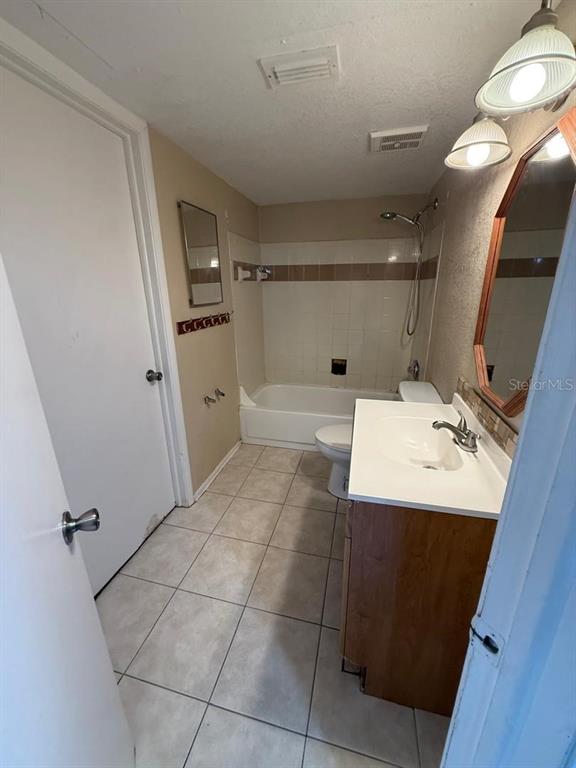 1908 Lake Atriums Circle, Unit 12 Orlando, FL 32839 - Photo 9 of 11 a bathroom with a sink a toilet and mirror