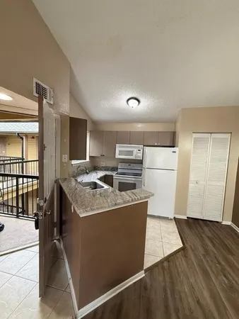 a kitchen with a stove top oven and refrigerator