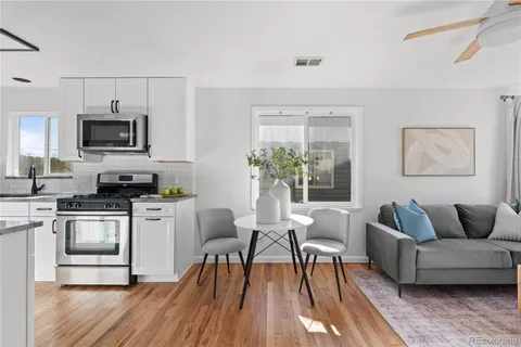 a living room with furniture a flat screen tv and kitchen view
