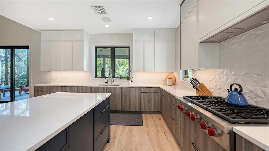5035 Bay Shore Road Sarasota, FL 34234 - Photo 22 of 84 a kitchen with sink a stove and chairs