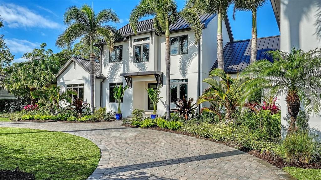 5035 Bay Shore Road Sarasota, FL 34234 - Photo 4 of 84 a front view of a house with a yard and potted plants