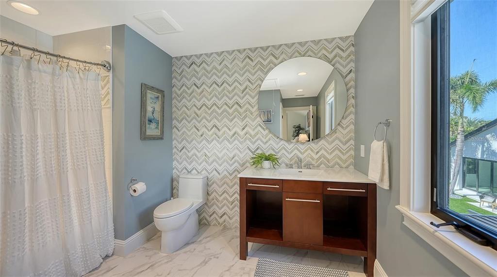 5035 Bay Shore Road Sarasota, FL 34234 - Photo 42 of 84 a bathroom with a granite countertop toilet sink and mirror