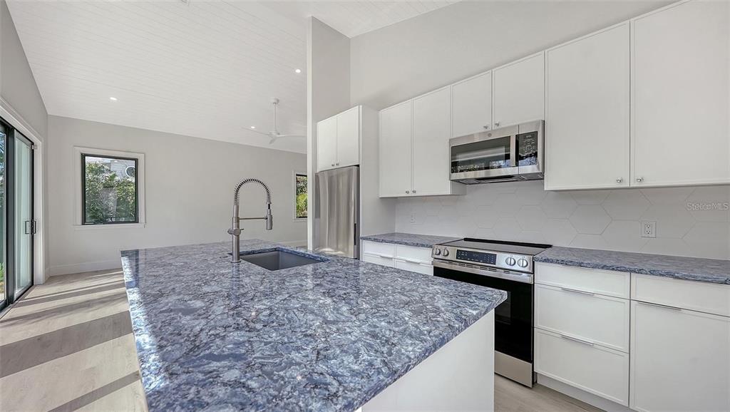 5035 Bay Shore Road Sarasota, FL 34234 - Photo 58 of 84 a kitchen with stainless steel appliances granite countertop a sink stove and microwave