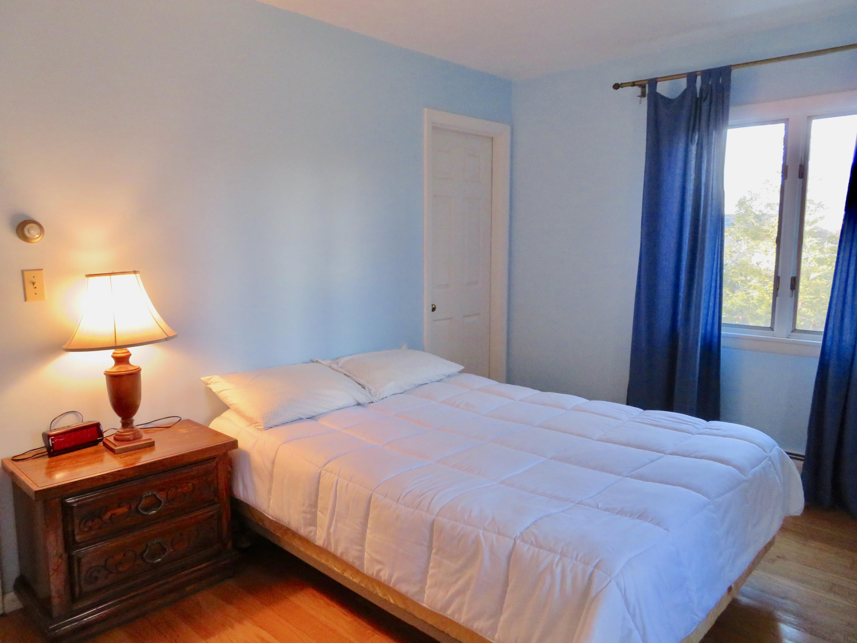 111 Elgin Road Pocasset, MA 02559 - Photo 11 of 34 a bedroom with a bed and a lamp on table