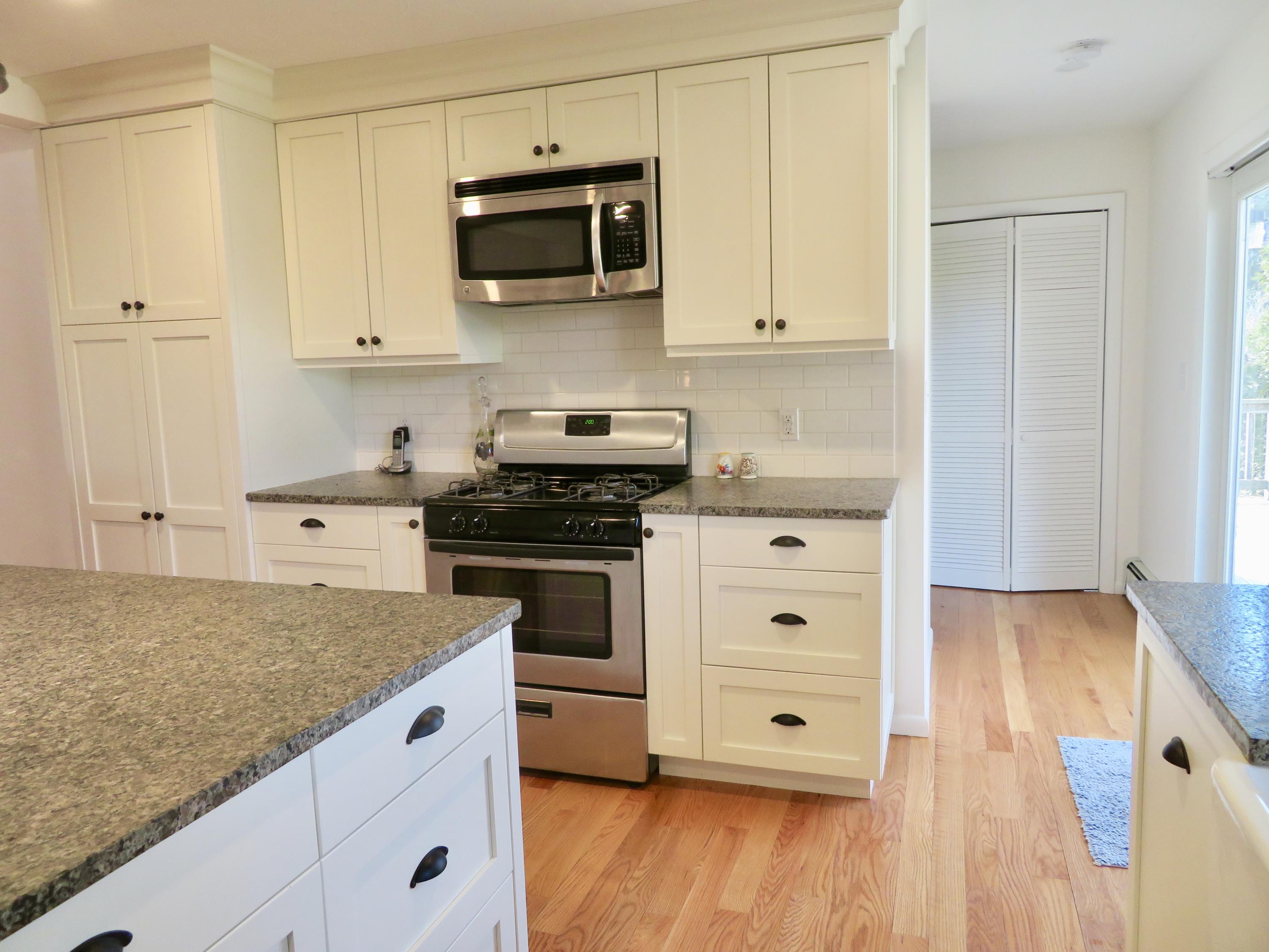 111 Elgin Road Pocasset, MA 02559 - Photo 6 of 34 a kitchen with granite countertop white cabinets and black stainless steel appliances
